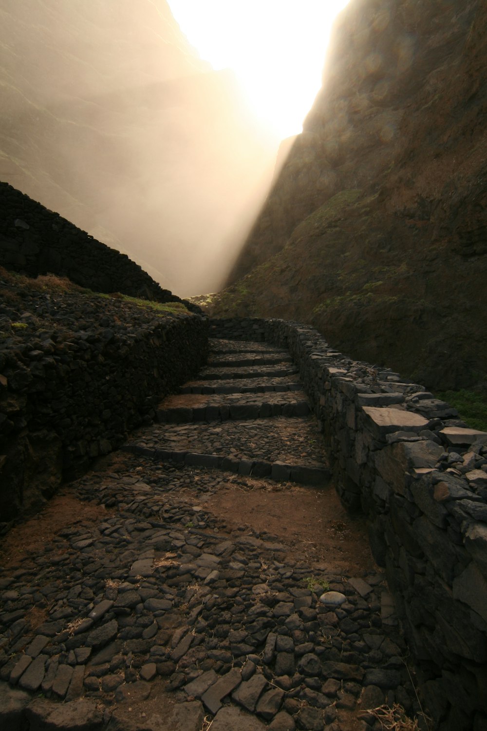 a stone path leading up to a mountain