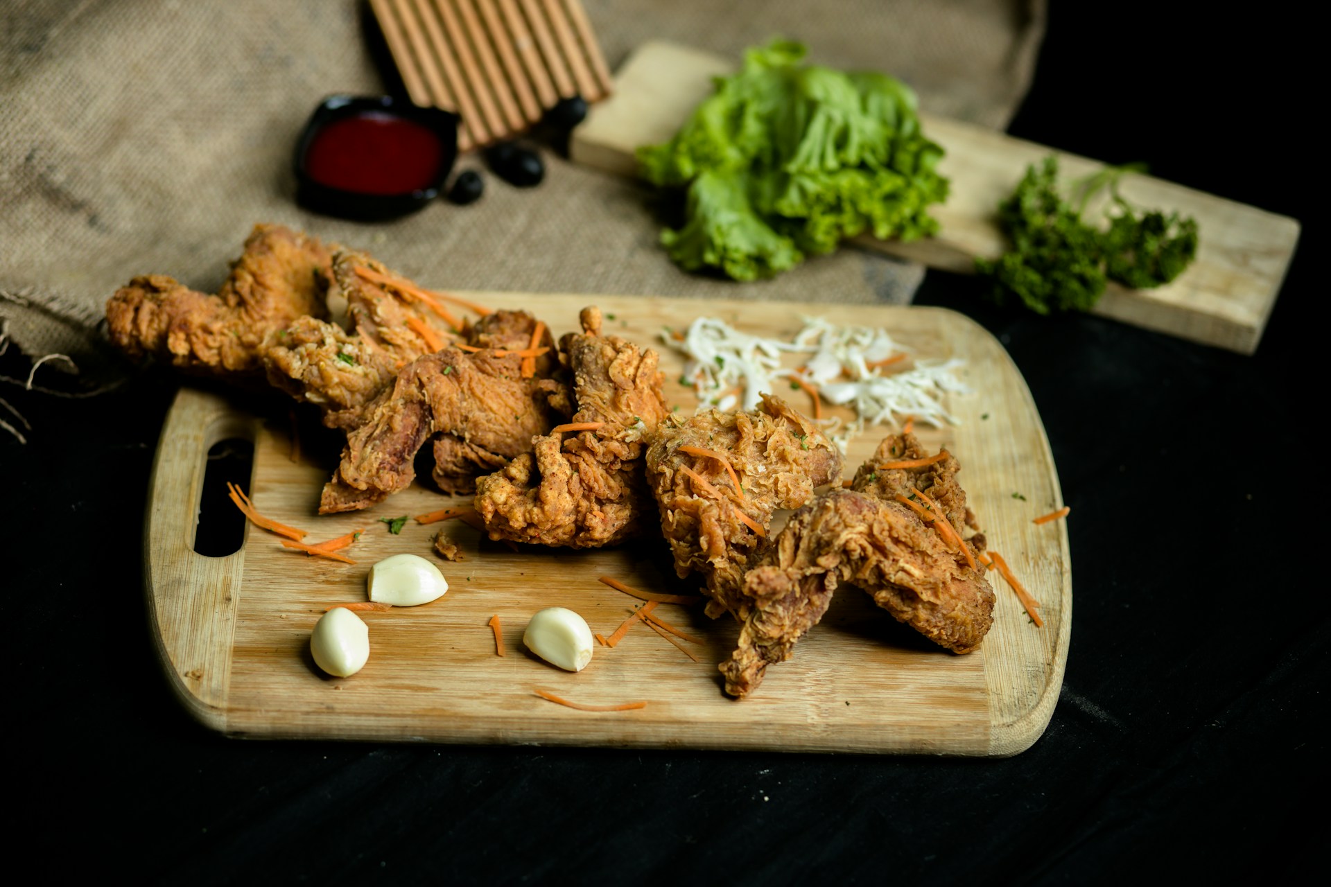 a wooden cutting board topped with meat and veggies