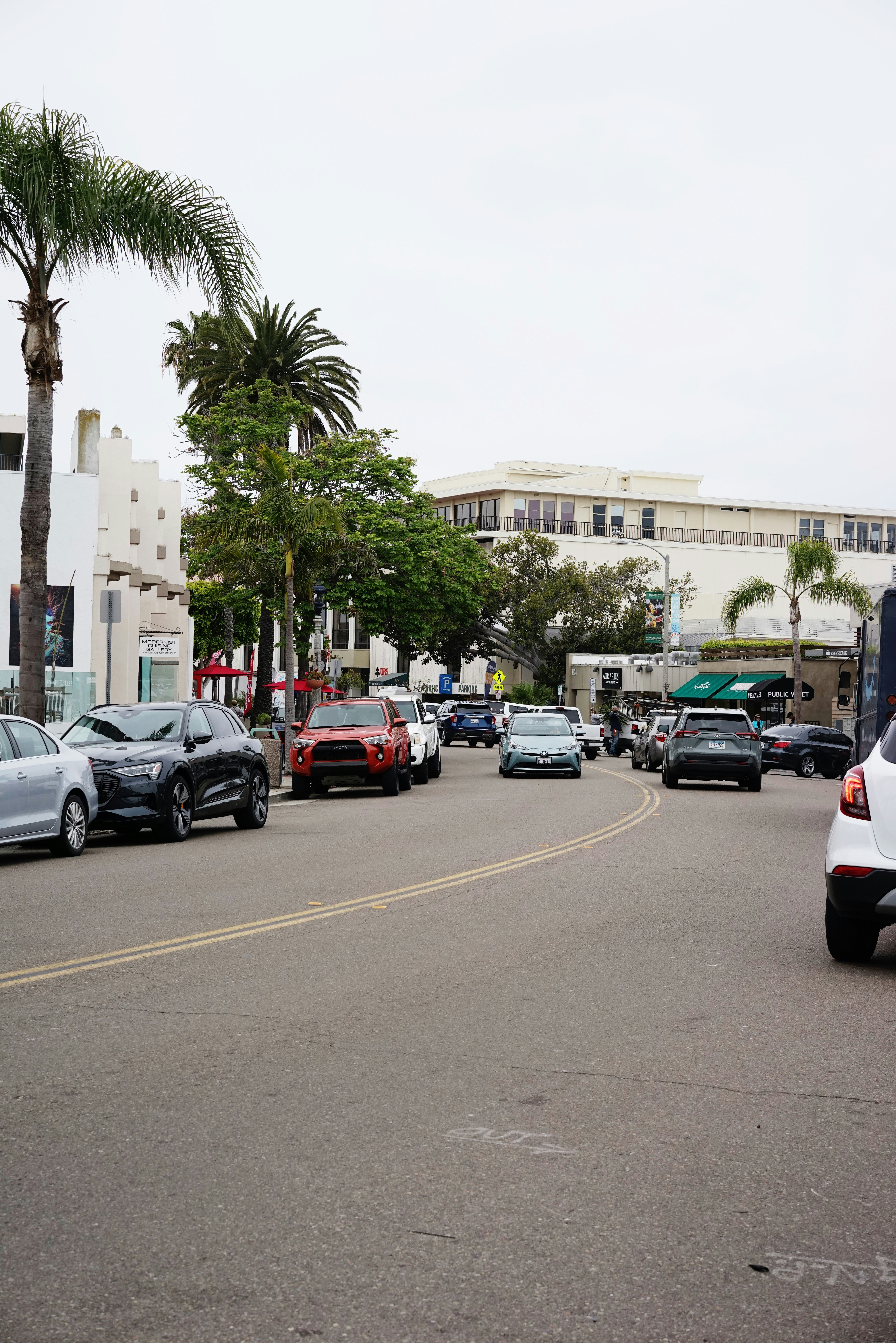 a street filled with lots of traffic next to tall buildings