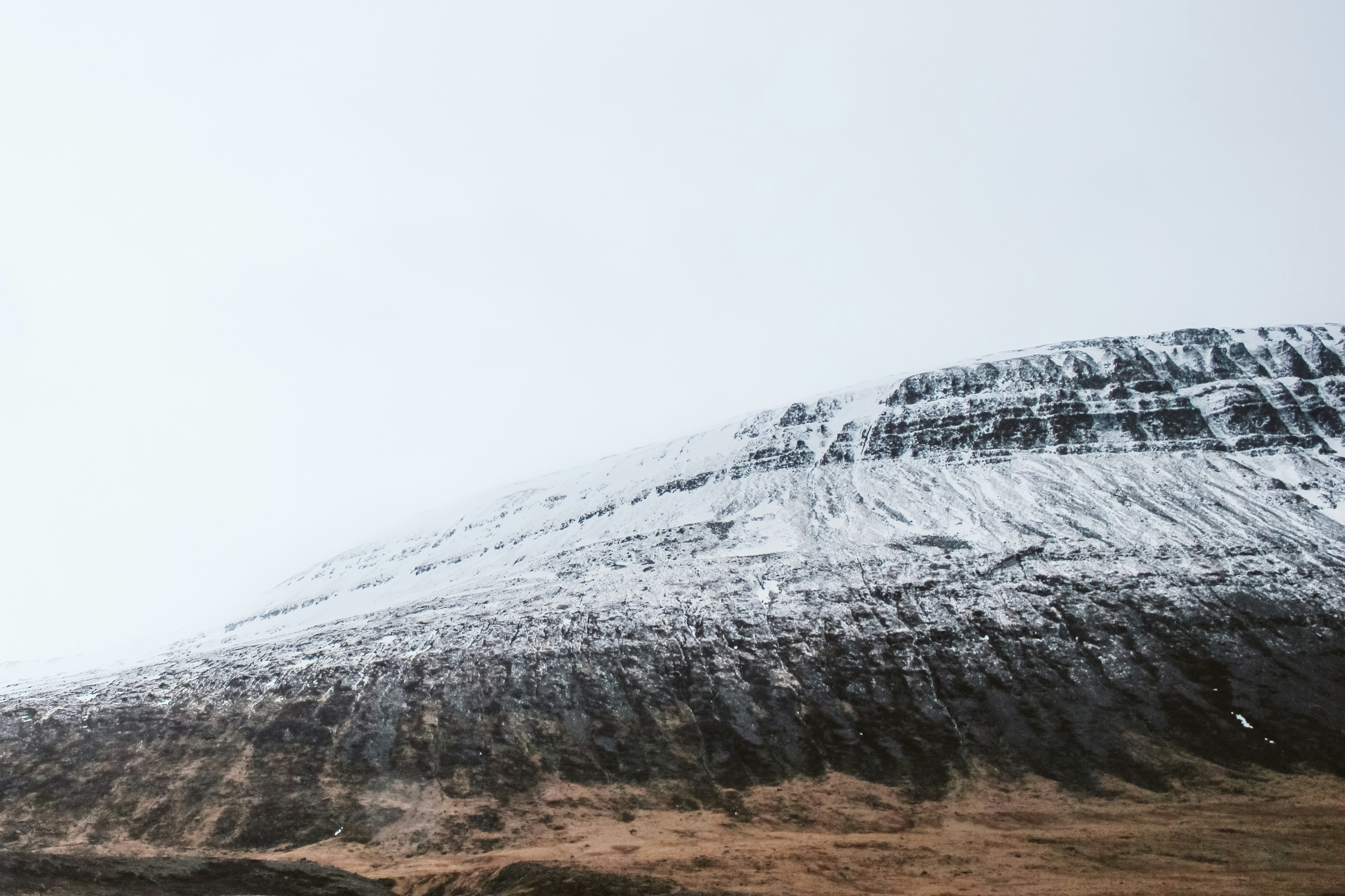 a mountain covered in snow on a cloudy day