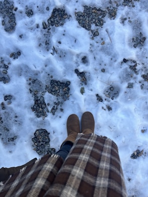 Warm winter boots placed on a snowy pathway.
