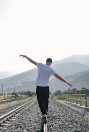 a man riding a skateboard down a train track