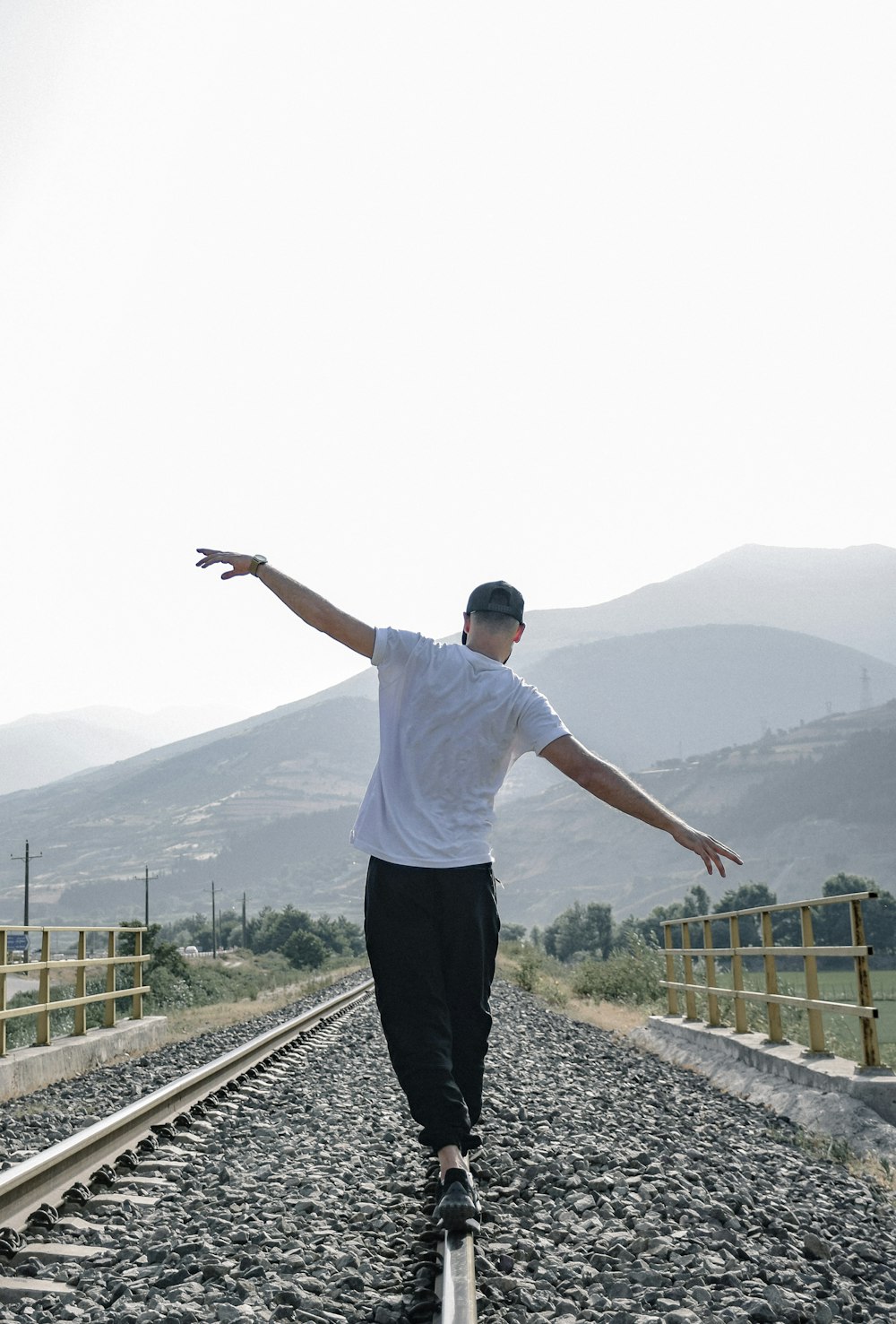 a man riding a skateboard down a train track