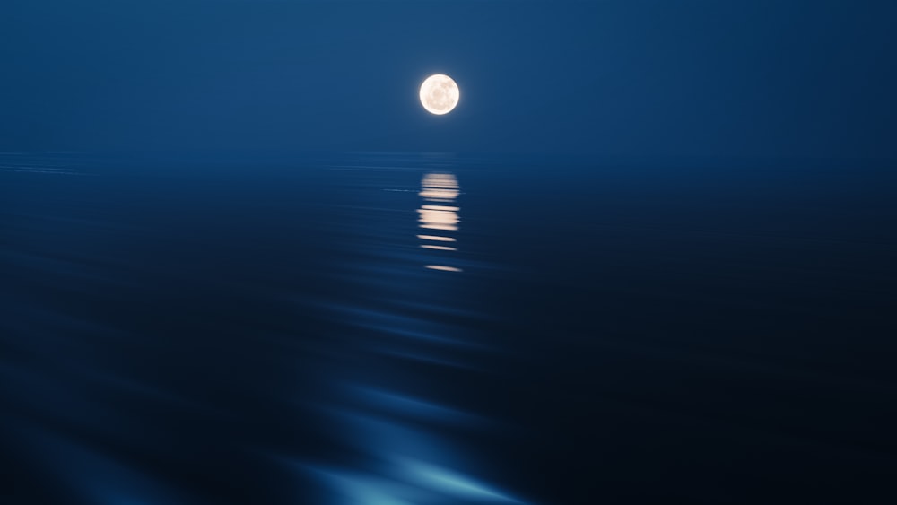 a full moon rising over the ocean at night