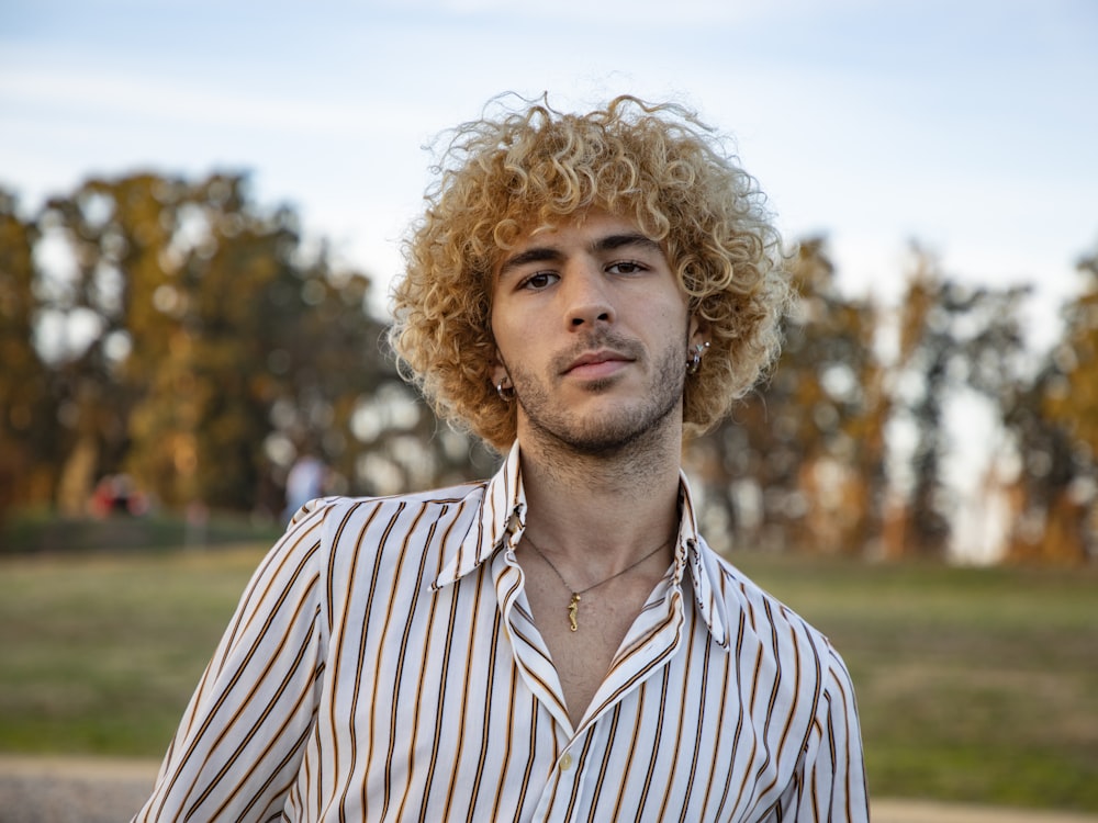 a man with curly hair wearing a striped shirt