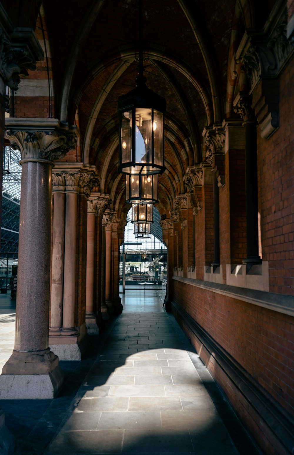 a long hallway with columns and a light hanging from the ceiling