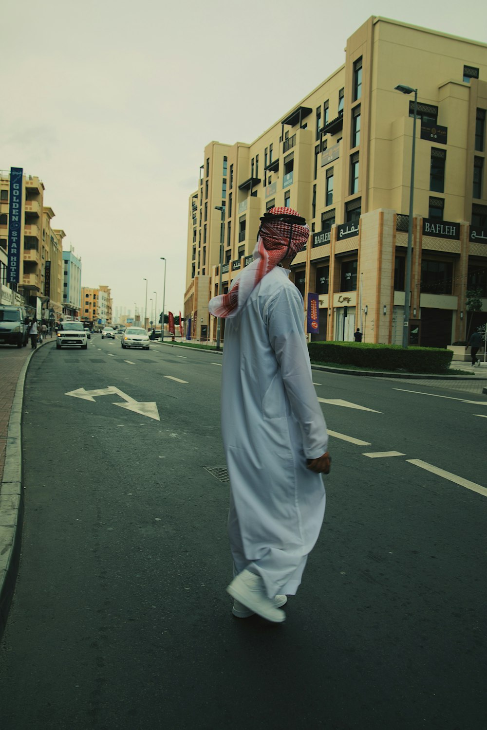 a man walking down a street in a white outfit