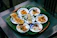 A happy customer enjoying a plate of traditional Tây Ninh bánh tráng in a cozy kitchen setting.