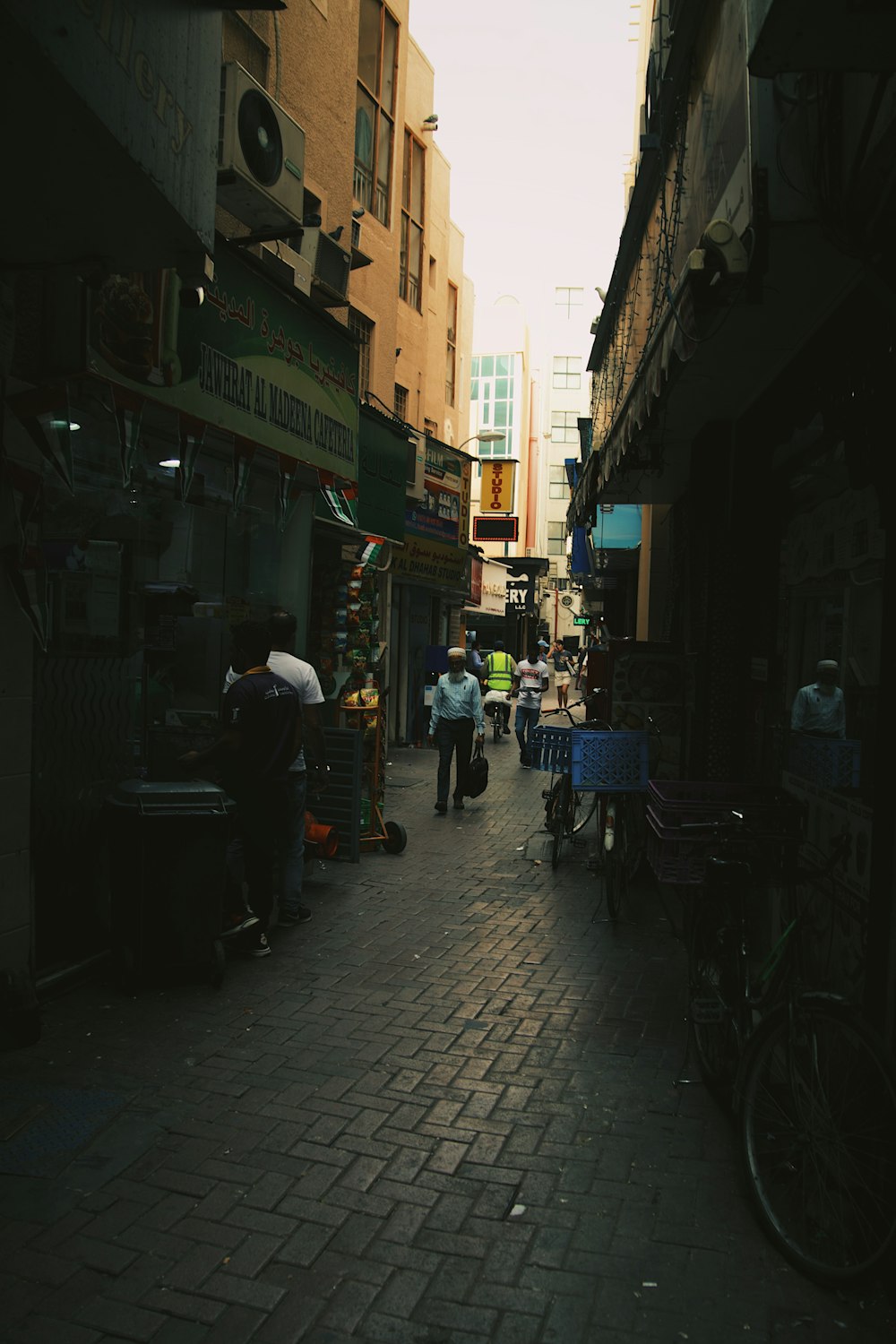 a group of people walking down a street next to tall buildings