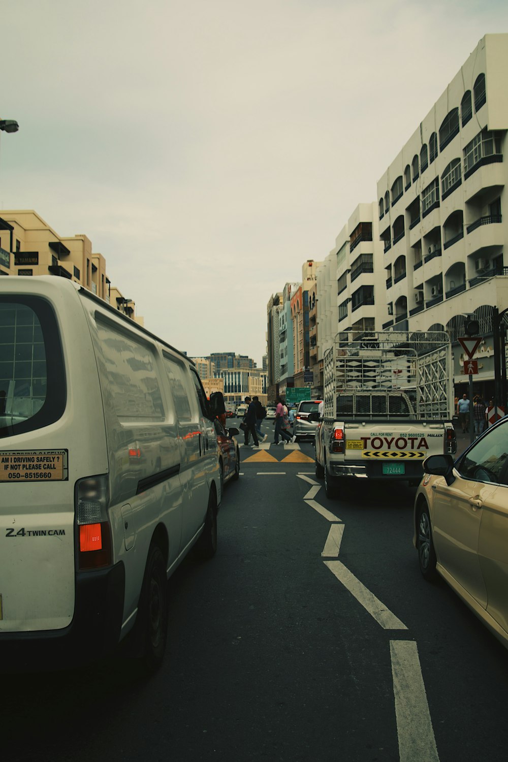 a city street filled with traffic next to tall buildings