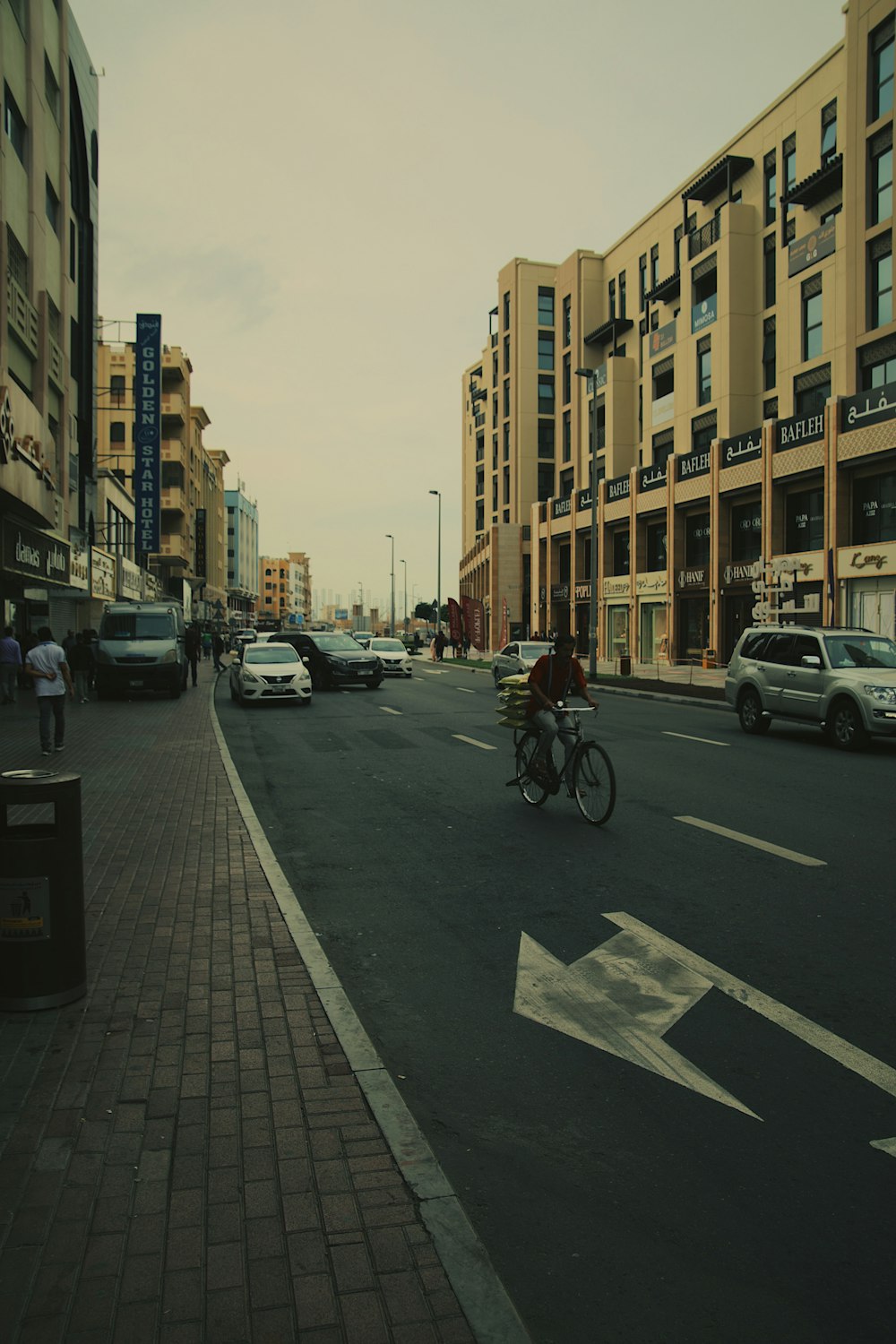 a man riding a bike down a street next to tall buildings