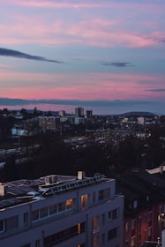 A modern Hong Kong skyline with solar panels and green rooftops glowing at sunset.