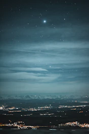 A detailed star map showing constellations over a city skyline at night.
