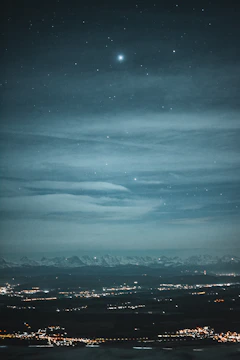 A detailed star map showing constellations over a city skyline at night.
