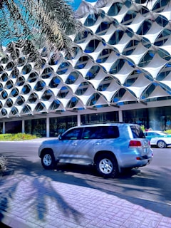 a silver suv parked in front of a building