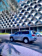 a silver suv parked in front of a building