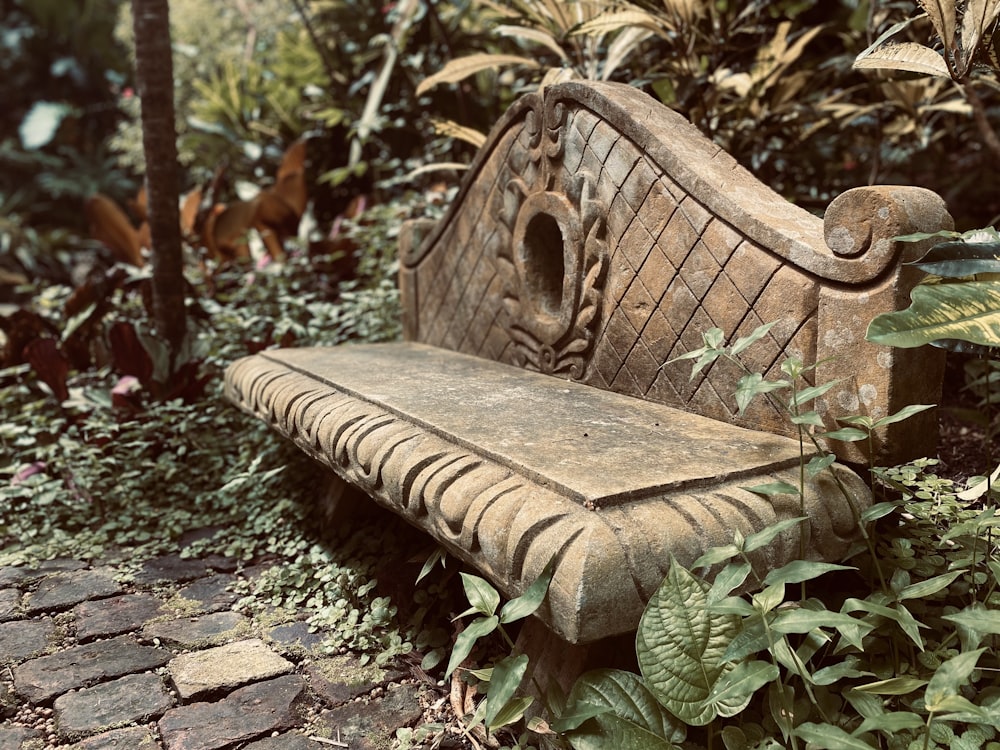 a stone bench sitting in the middle of a garden