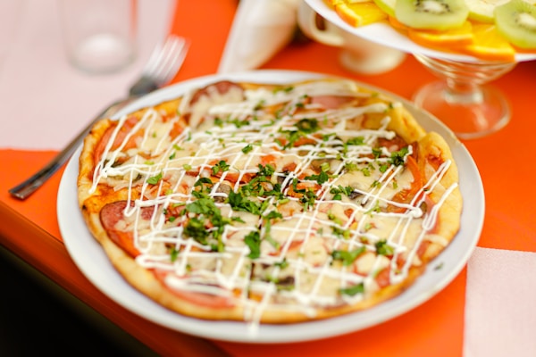 A pizza with cheese and vegetables on a plate