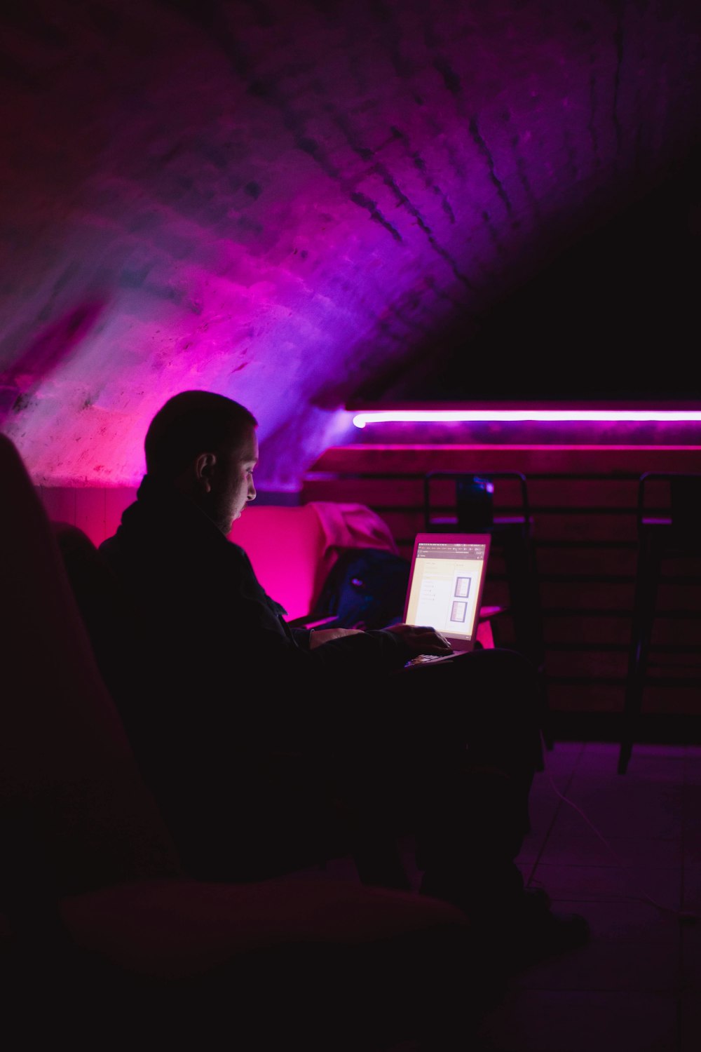 a man sitting in a chair in front of a laptop computer