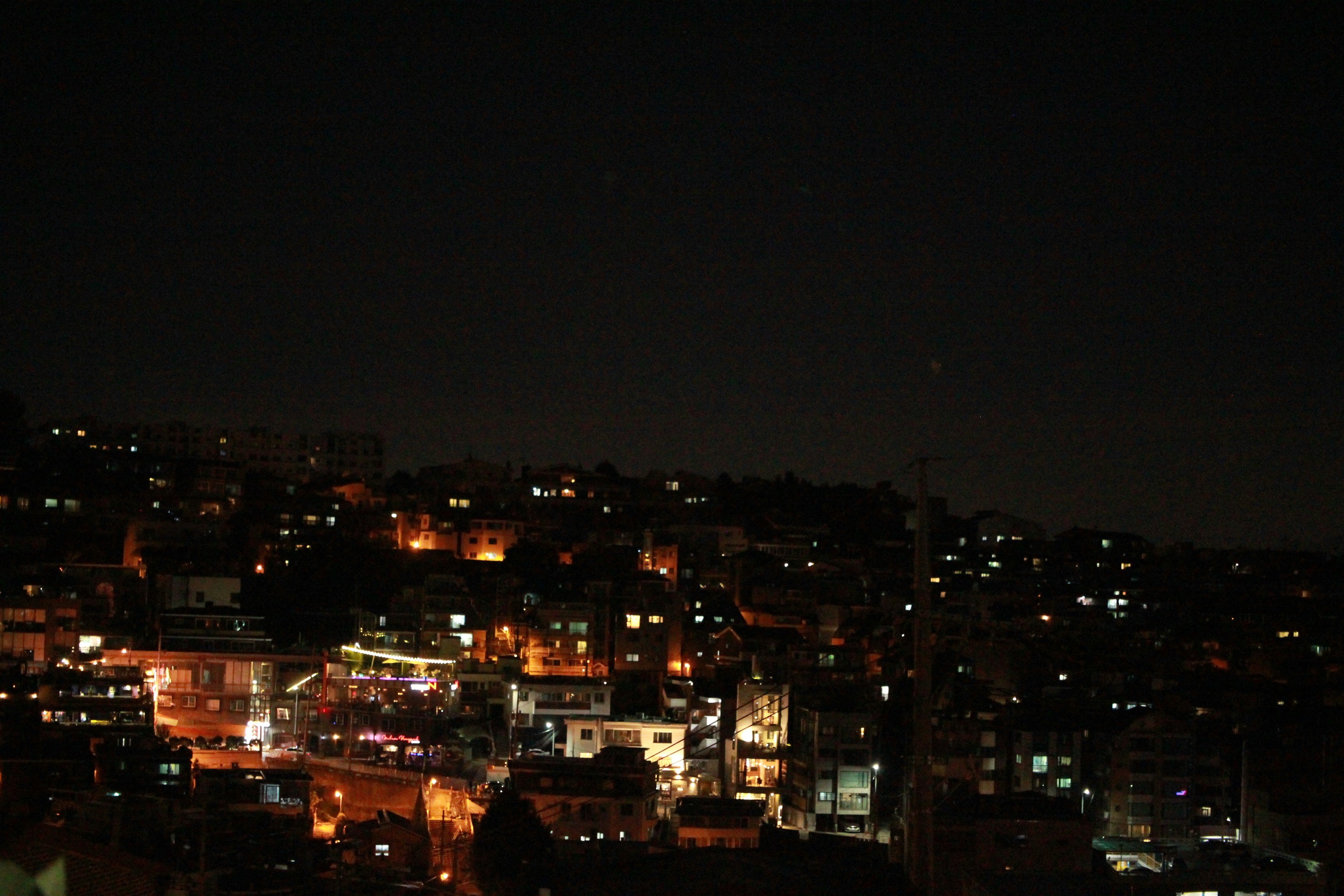 a night view of a city with buildings lit up, 