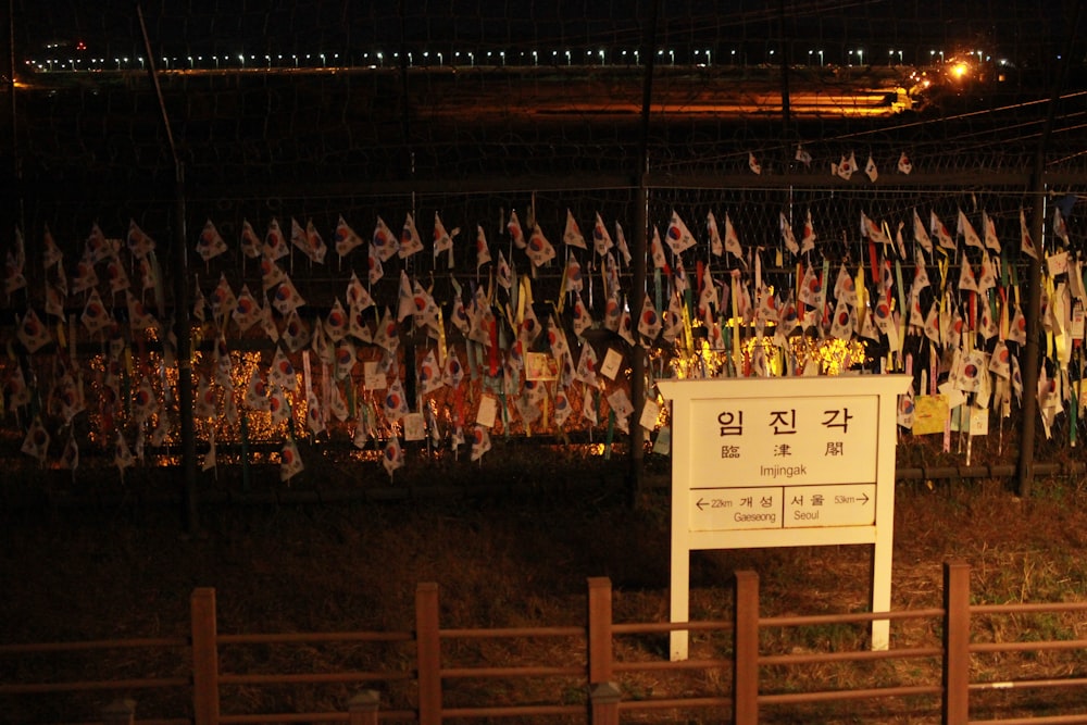 a fence with a bunch of flags hanging on it