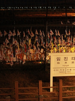 a fence with a bunch of flags hanging on it