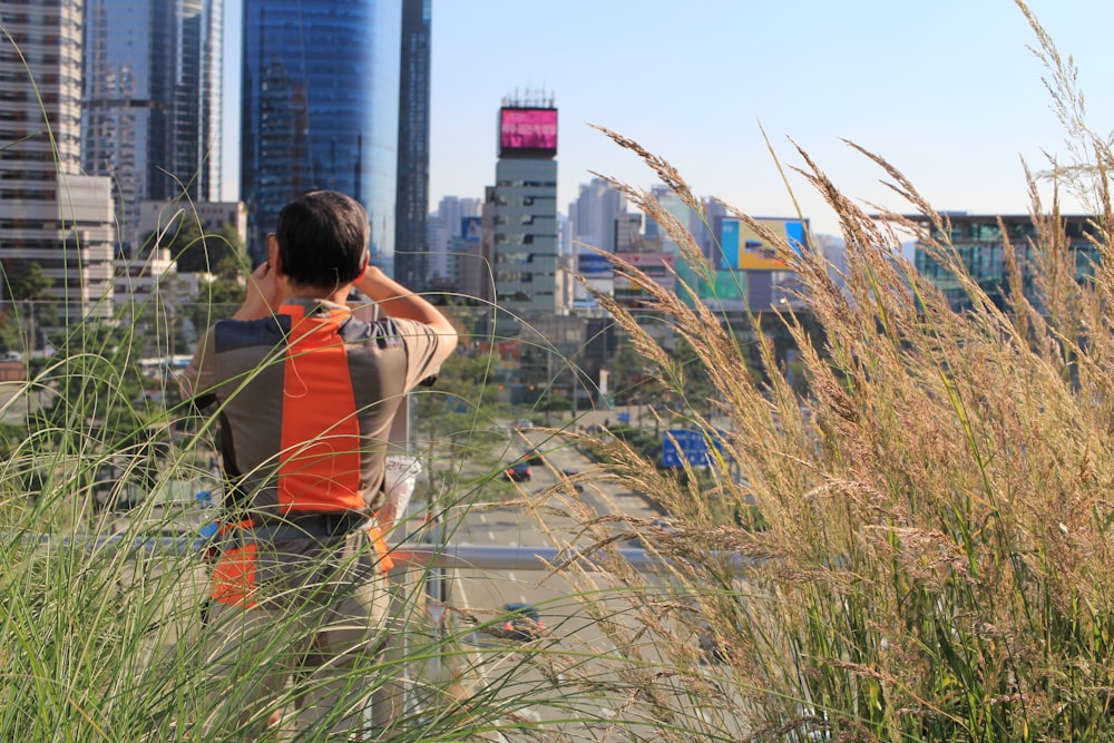 a man standing on top of a tall grass covered field