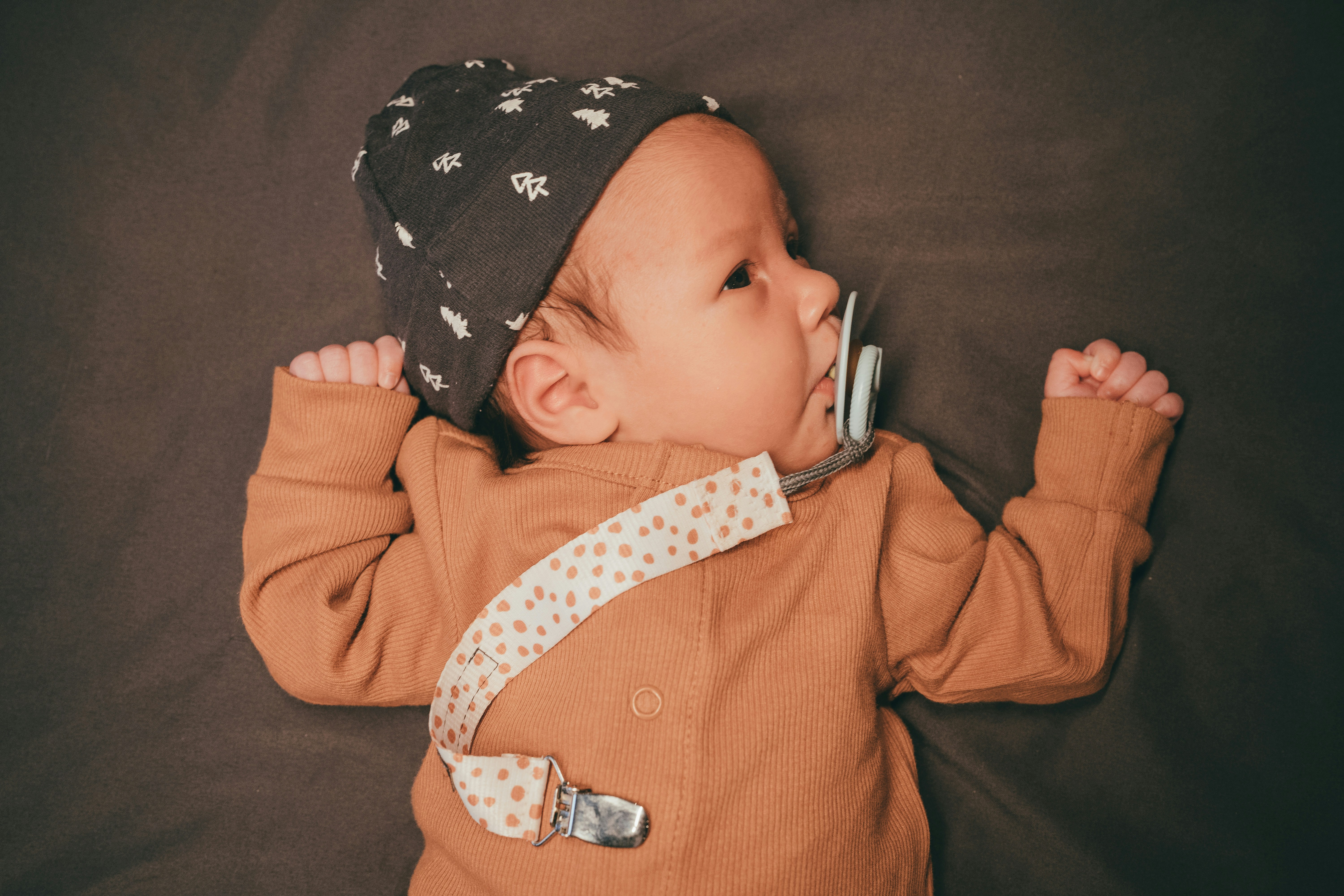 en bebis som ligger på en säng och håller i en kam