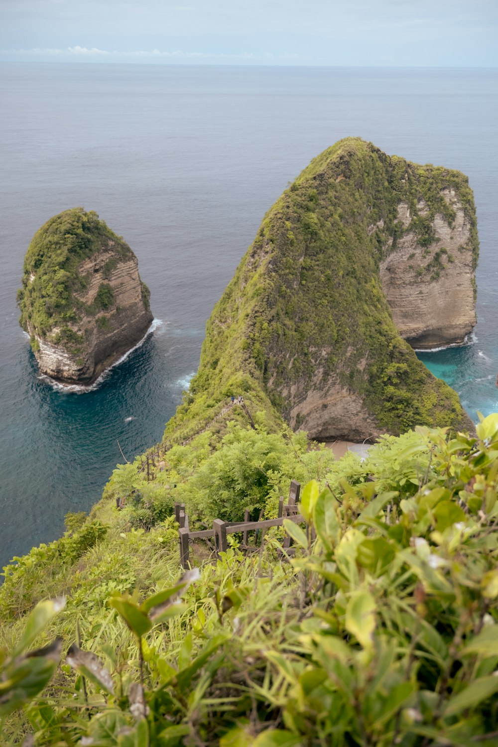 a couple of large rocks sitting on top of a lush green hillside