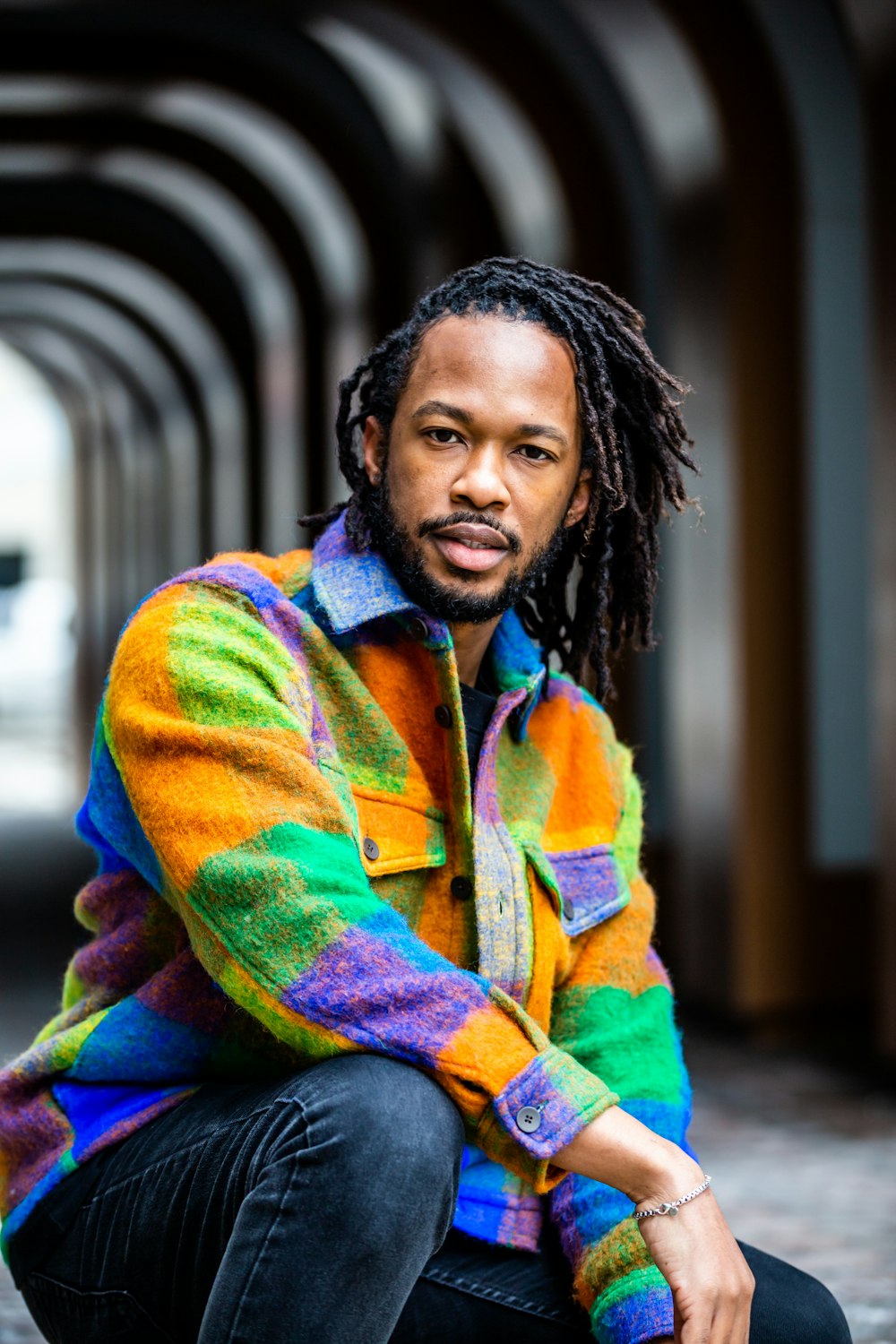 a man with dreadlocks sitting on the ground