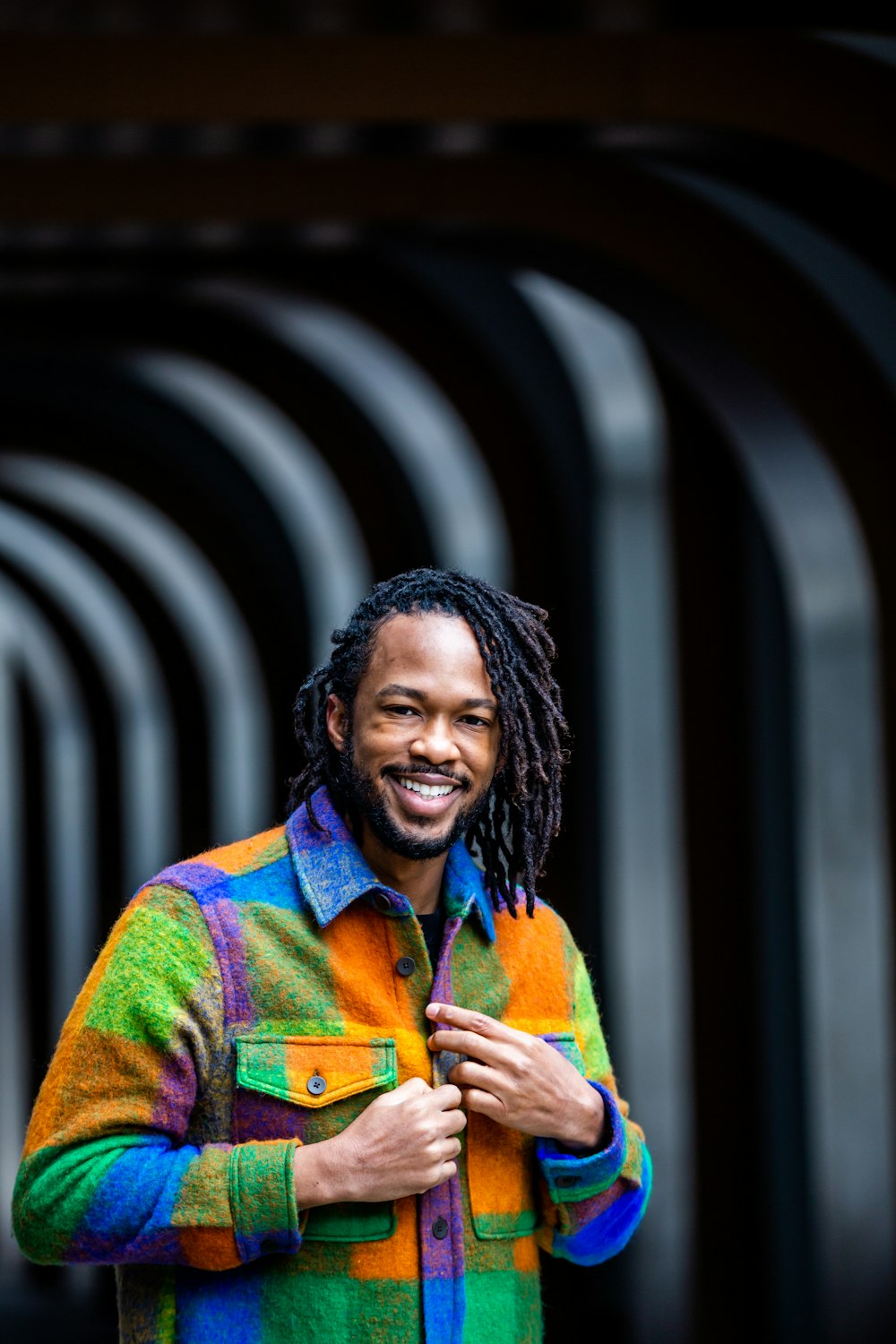 a man with dreadlocks standing in front of a building