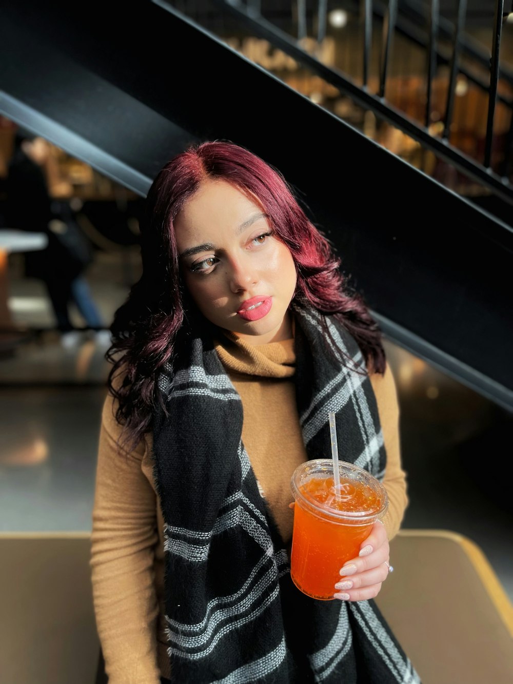 a woman with red hair holding a drink