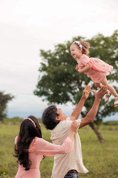 a man holding a little girl up in the air
