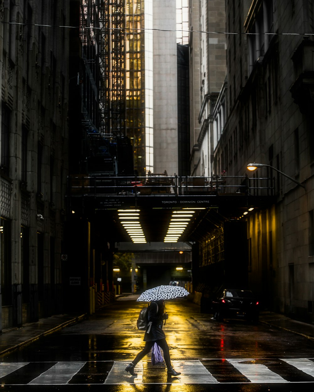 a person walking down a street holding an umbrella