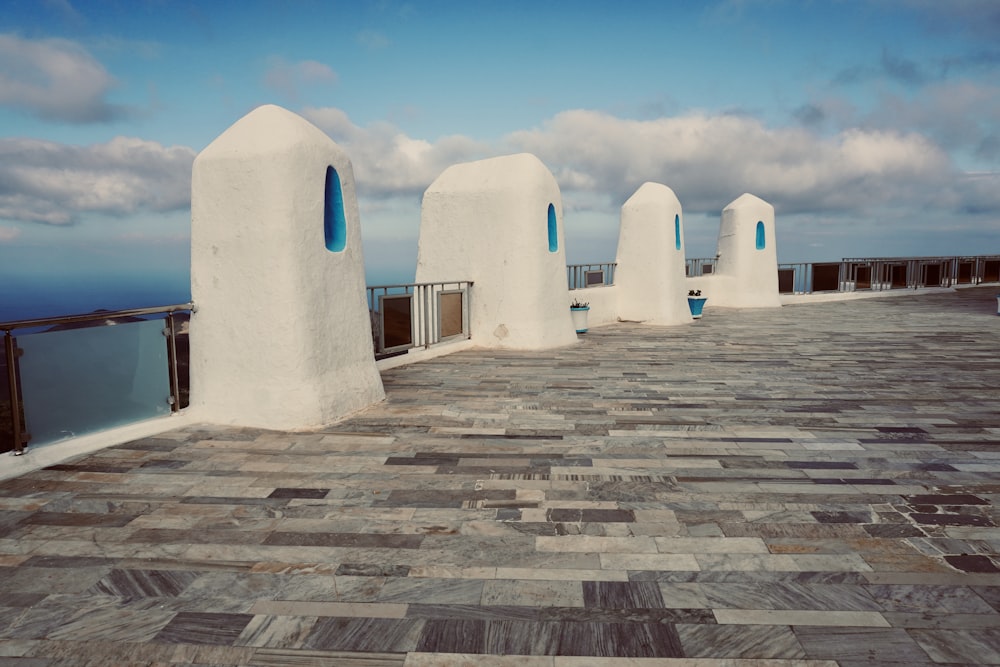 a row of white buildings sitting on top of a stone floor