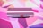 A close-up of a colorful notebook open on a wooden desk with a pen beside it.