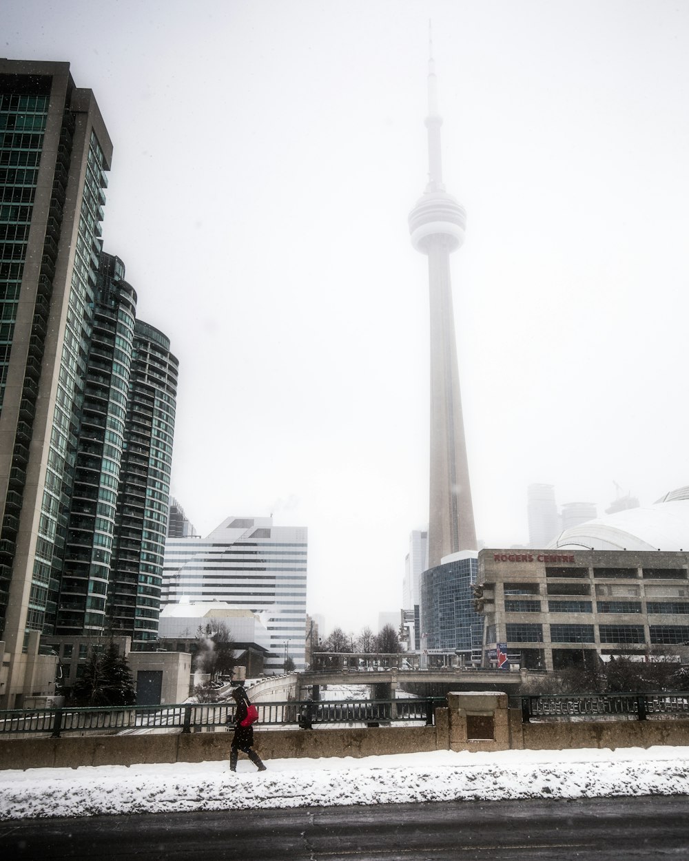 a person walking in the snow in front of a tall building