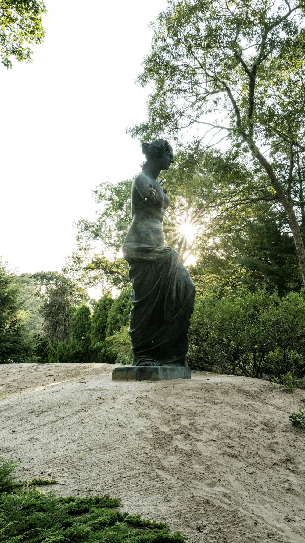 Eine Statue einer Frau, die auf einem Hügel sitzt