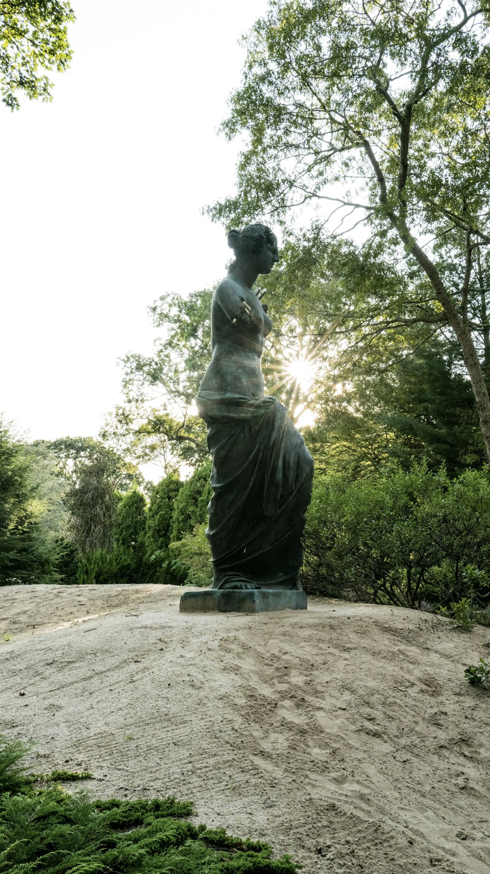 언덕 꼭대기에 앉아 있는 여성의 동상