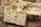 Close-up view of freshly baked bread pieces with a crisp, textured crust and a soft, airy interior. The bread is displayed on a wooden surface, highlighting its fluffy texture and golden-brown hue.