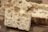 Close-up view of freshly baked bread pieces with a crisp, textured crust and a soft, airy interior. The bread is displayed on a wooden surface, highlighting its fluffy texture and golden-brown hue.