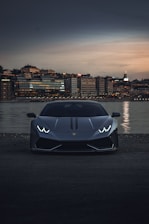 A sleek, customized sports car parked in front of a modern Toronto skyline at dusk.