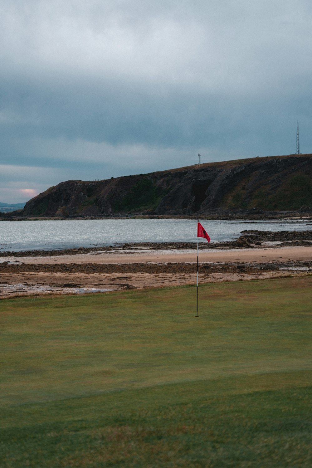 a flag on a golf course near a body of water