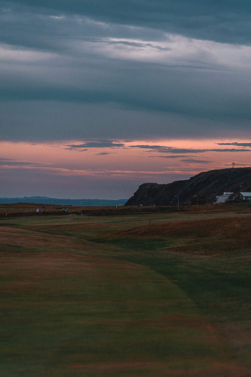 Scottish links golf course at sunset with coastal cliffs