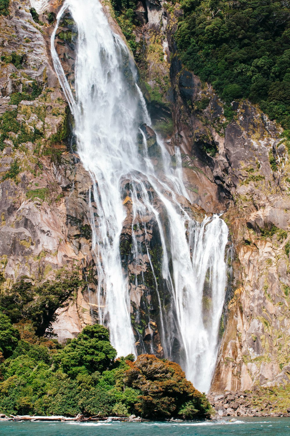 a large waterfall in the middle of a body of water