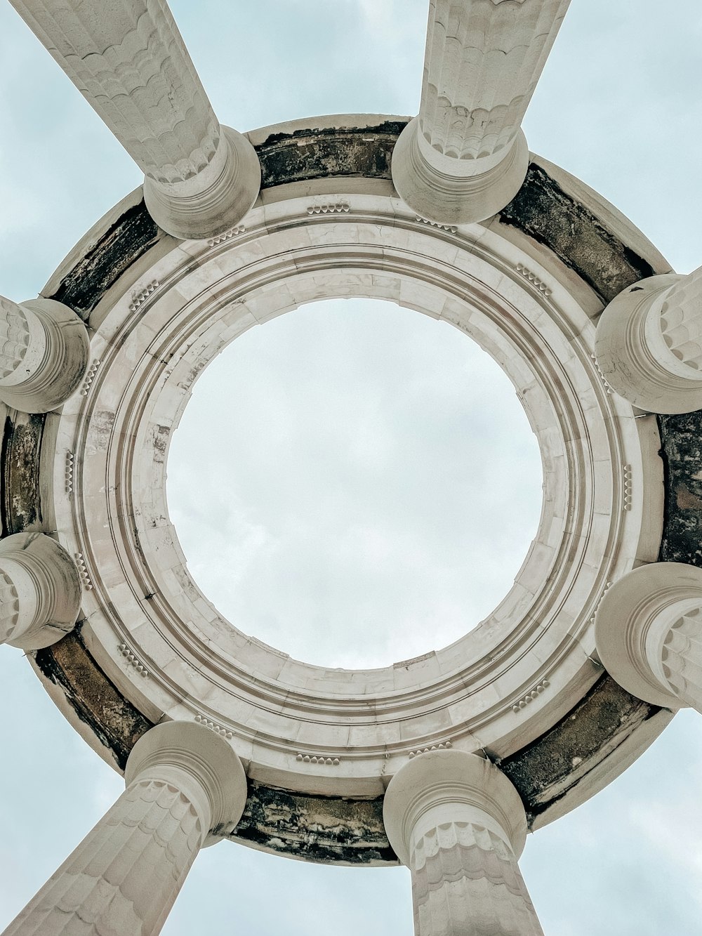 a circular view of a building with columns and a sky background