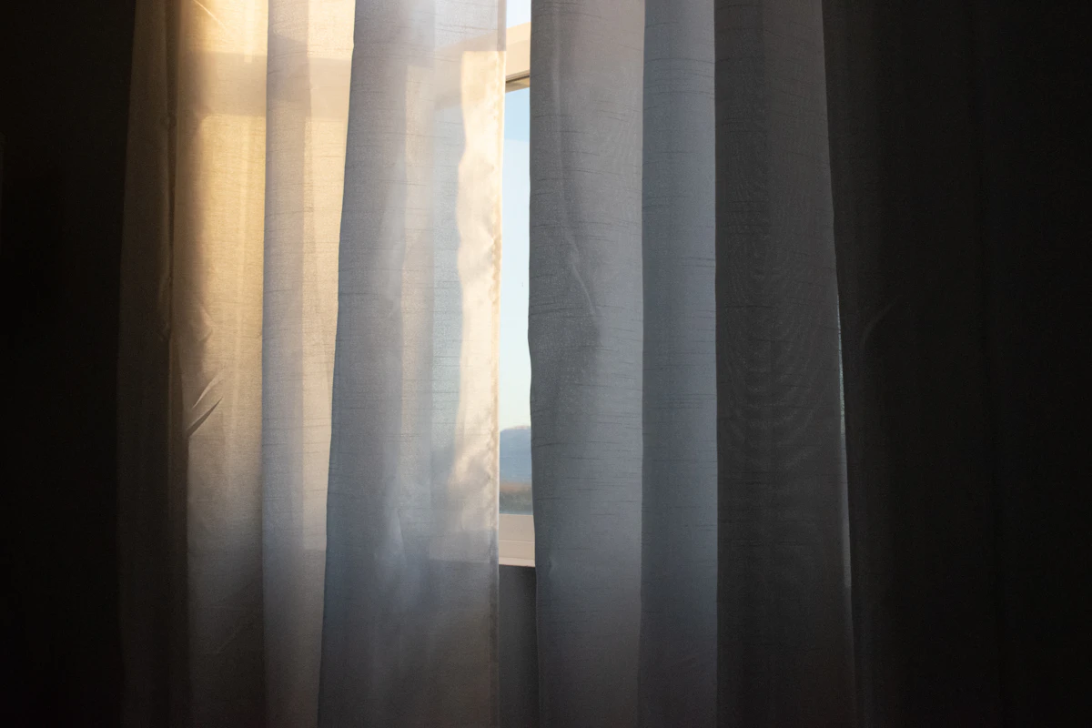 Close view of heavy window curtains filtering daylight