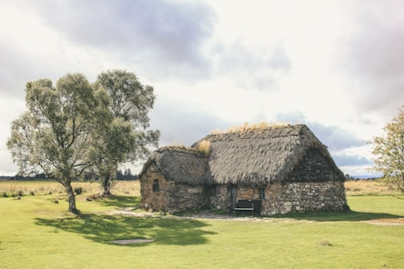 an old stone house with a thatched roof