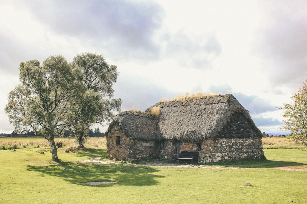 an old stone house with a thatched roof