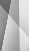 Intersecting geometric shapes created by light and shadow in various tones of gray.